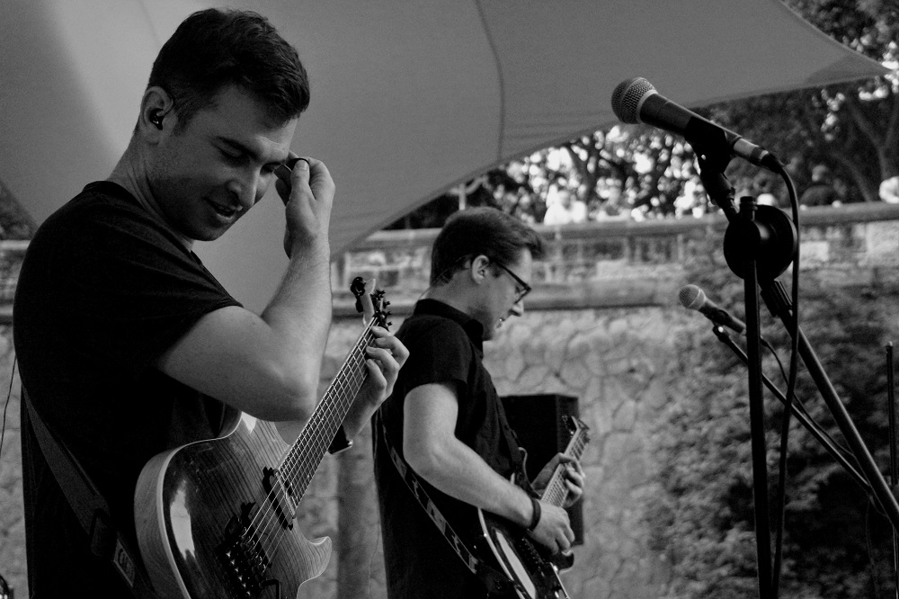 Zwei der Musiker von der Band Klangapart stehen mit Bass und E-Gitarre auf der Bühne bei einem Live-Auftritt.