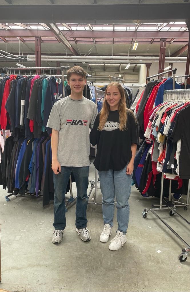 Pictured are Daniel Bayen and Mira Fandel in front of clothing racks.